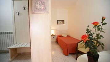 Une chambre à coucher avec un lit, une chaise, une plante en pot et un radiateur.