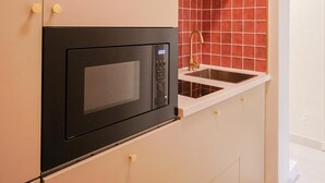 Eine Küche mit eingebauter Mikrowelle, einem Spülbecken und Holzschränken.