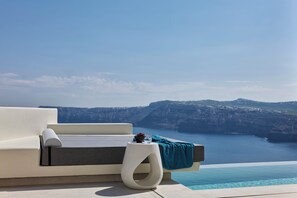 Un espace extérieur moderne, aménagé avec des sièges et une piscine, offrant une vue panoramique sur une falaise pittoresque.