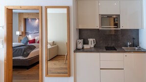 A modern kitchen with a built-in oven, a sink, and a coffee maker.