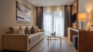 A modern living room with a sofa, a coffee table, and a TV on a wooden cabinet.