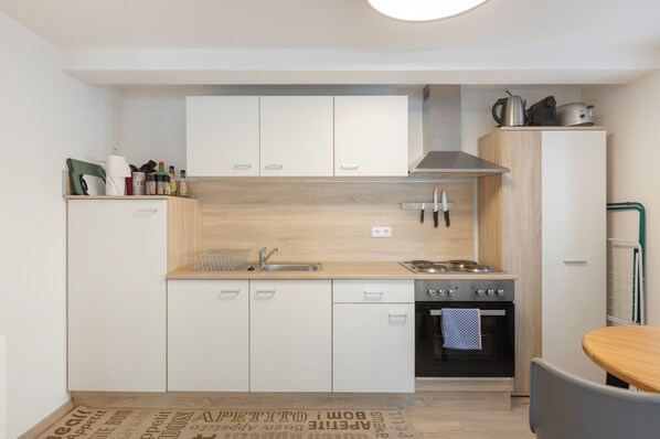 A modern kitchen with white cabinets, a stainless steel sink, and a built-in oven. - Apartment "Fewo Im Schönen Allensbach" with Lake View and Wi-Fi (Allensbach)