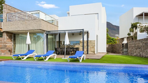 A modern pool area with lounge chairs and a covered seating area. - Private Villa with Pool - Close to the Beach (Costa Adeje)