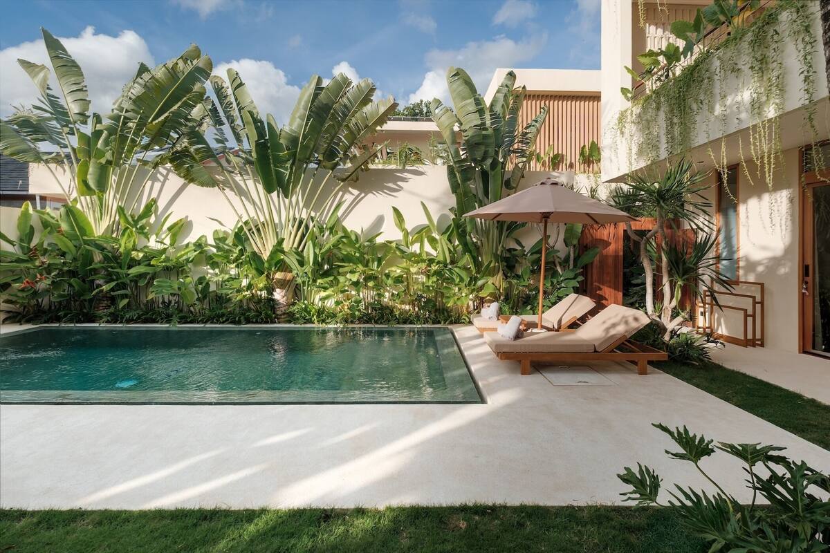 A pool area with lounge chairs and a wooden deck.