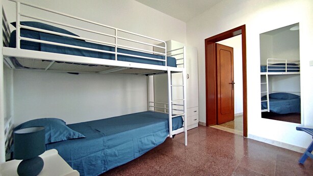 A bunk bed room with a wooden door, a small table, and a mirror. - La Casetta Di Novaglie - Puntaverde Con Vista Mare (Alessano)