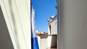 A narrow corridor with a blue curtain, a tiled floor, and a small door. - La Casetta Di Novaglie - Puntaverde Con Vista Mare (Alessano)