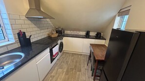 Eine kleine Küche mit Spüle, Mikrowelle, Toaster und Kühlschrank.