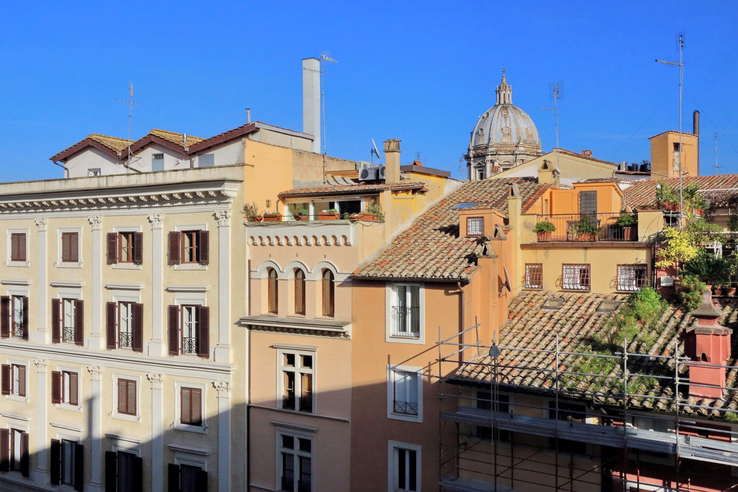 A historic building with a dome and a bell tower, surrounded by other buildings with traditional architecture.