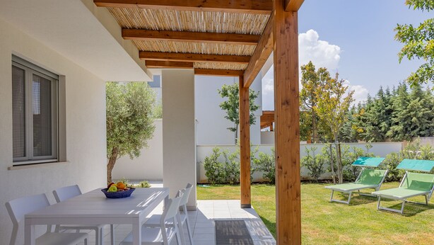 An outdoor patio with a table and chairs, a woven ceiling, and a view of the garden. - Color Dream Residence- Intimate Suite Pink (Capitolo)