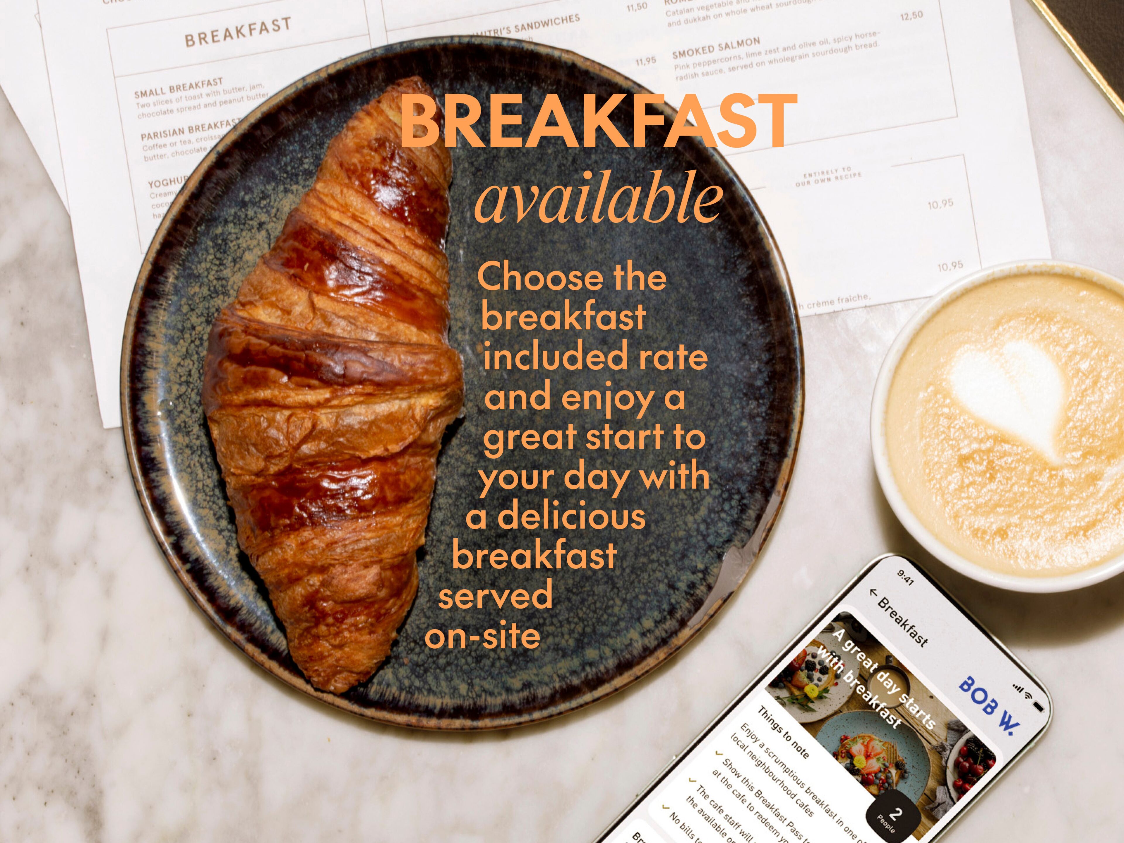 Een croissant op een bord, een kop koffie en een menukaart met ontbijtopties.