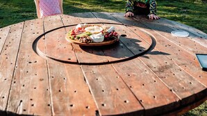 Two children at a wooden table with a food platter in a grassy outdoor setting. - Plain Bush by Tiny Away (Bohena Creek)