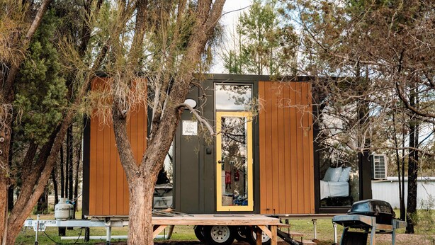 A small cabin with a door, a window, and a ramp leading to a vehicle. - Plain Bush by Tiny Away (Bohena Creek)