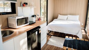 A compact room with a kitchenette, a bed, and a view of the outdoors. - Plain Bush by Tiny Away (Bohena Creek)