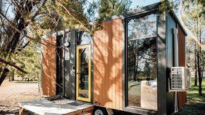 A small, modern mobile home with a wooden exterior, a sliding door, and a small porch with steps. - Plain Bush by Tiny Away (Bohena Creek)
