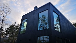 Un bâtiment moderne doté de grandes fenêtres et d’une façade sombre.