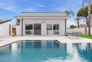 A modern house with a swimming pool, patio chairs, and a clear blue sky. - Villa Lux Syracuse Arenella just minutes from the most famous beach. (Syracuse)