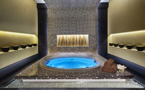 A spa area with a hot tub, tiled walls, and shelves with bowls. - Executive stay with hotel facilities (Dubai)