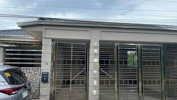 A gated entrance with a metal gate and a concrete wall.
