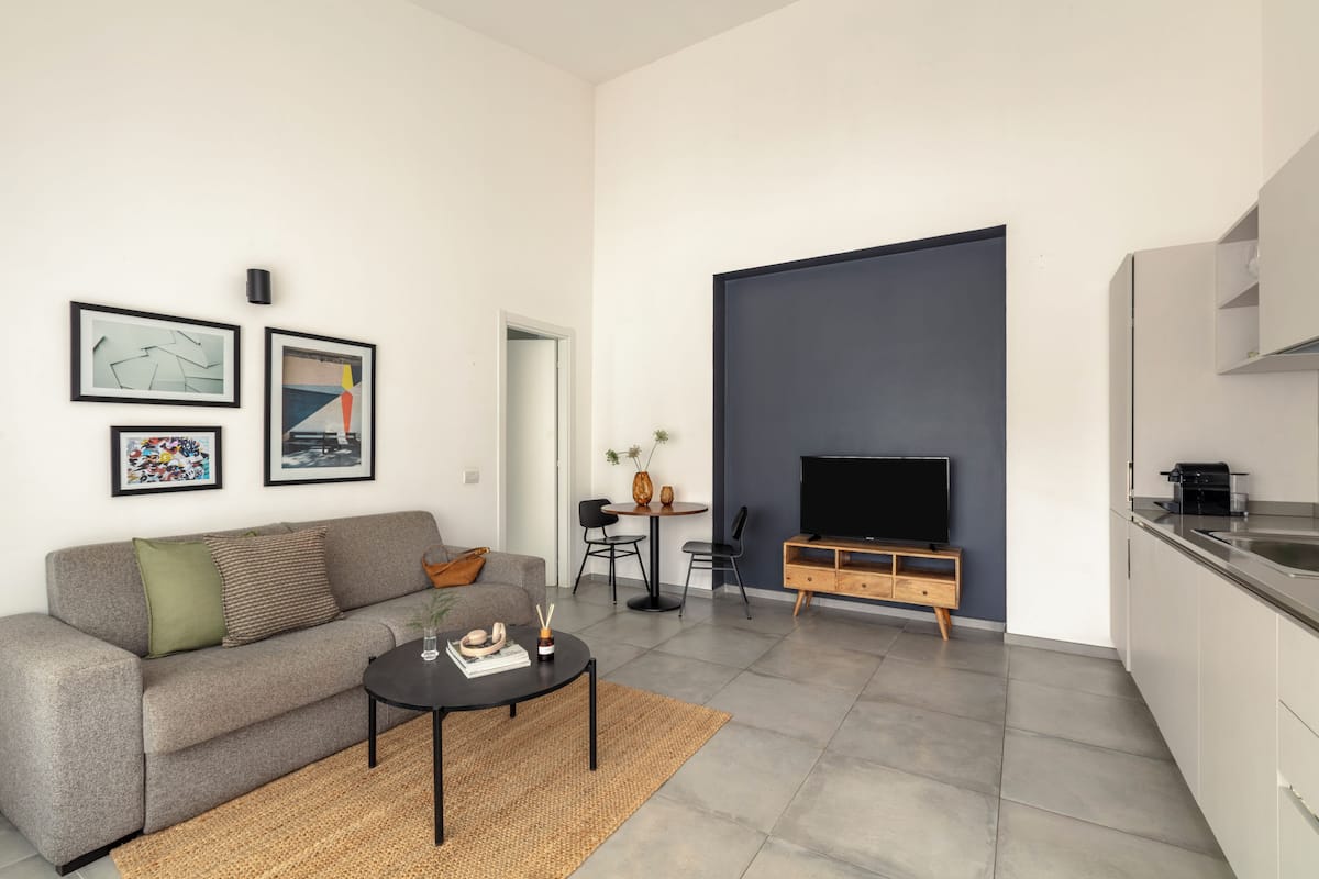 A modern living room with a sofa, coffee table, and artwork on the wall.