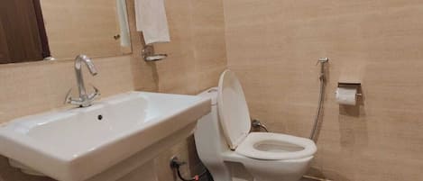Un baño con lavamanos, inodoro y espejo.