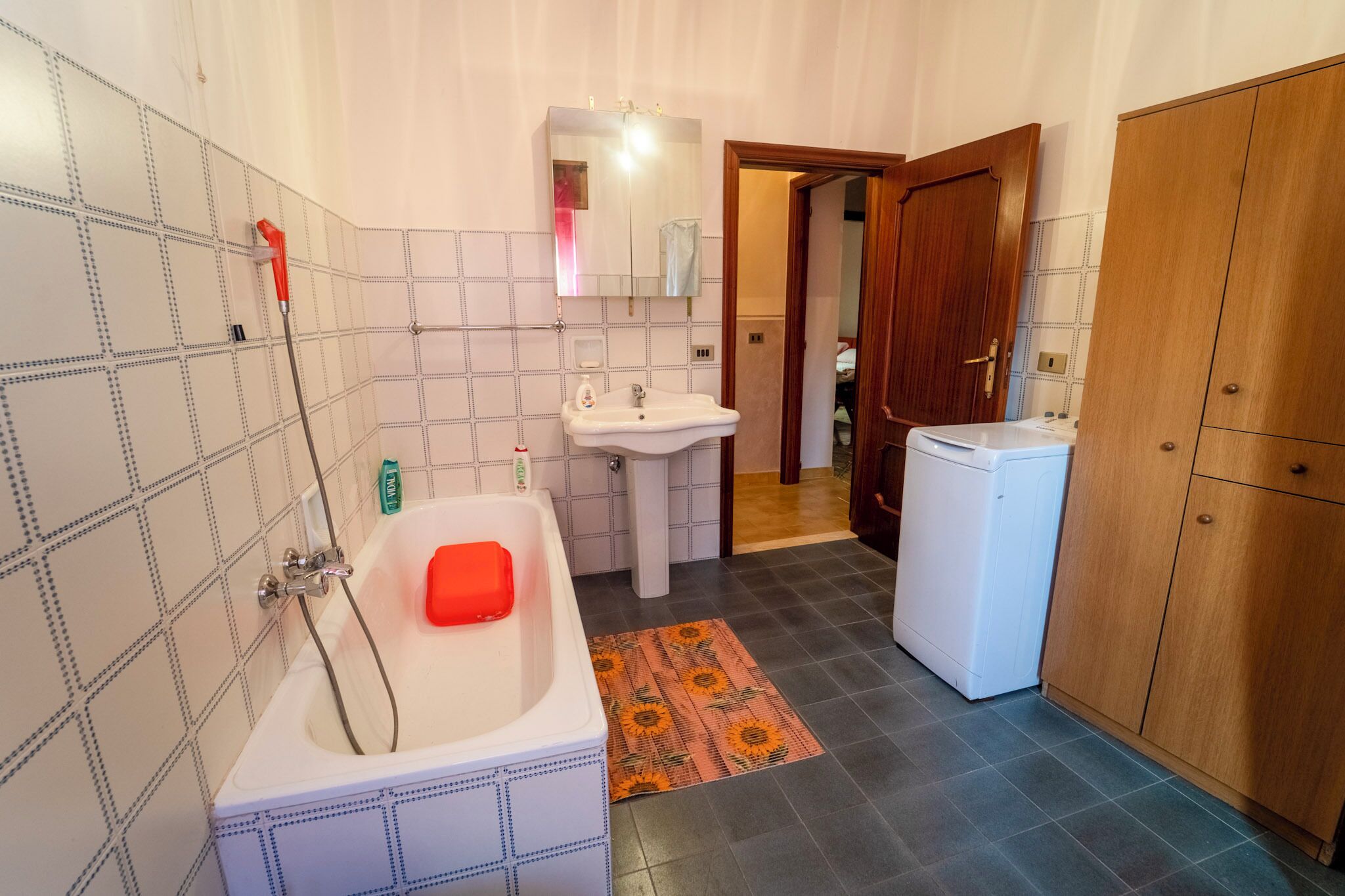 A bathroom with a bathtub, a sink, a mirror, and a shower.