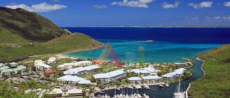A coastal resort with multiple buildings, a marina, and a view of the ocean.
