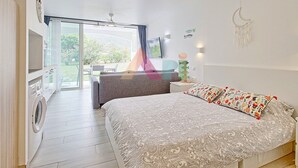 A bedroom with a bed, a desk, and a washing machine. - Studio in Anse Marcel (Saint-Martin)