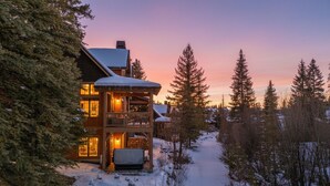 A wooden lodge with a balcony, surrounded by snow-covered trees and a clear sky. - Ski in/out to Tamarack Express Chairlift, pet-friendly, AC, hot tub (Tamarack)