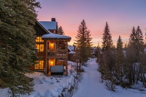 A wooden lodge with a balcony, surrounded by snow-covered trees and a clear sky. - Ski in/out to Tamarack Express Chairlift, pet-friendly, AC, hot tub (Tamarack)