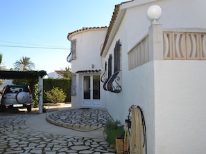A house with a tiled entrance, a garage, and a parked car. - Villa in Els Poblets, Spain (Denia)