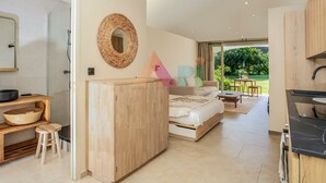 Un espacio habitable moderno y abierto con kitchenette, zona de comedor y un amplio ventanal con vistas al exterior.