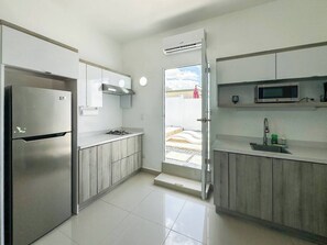 A modern kitchen with a stainless steel refrigerator, a microwave, and a sink. - CASSIOPEIA APARTMENT (Hatillo)