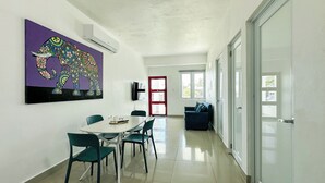 Um interior moderno com área de refeições, um quadro de um elefante colorido e vista para o exterior.