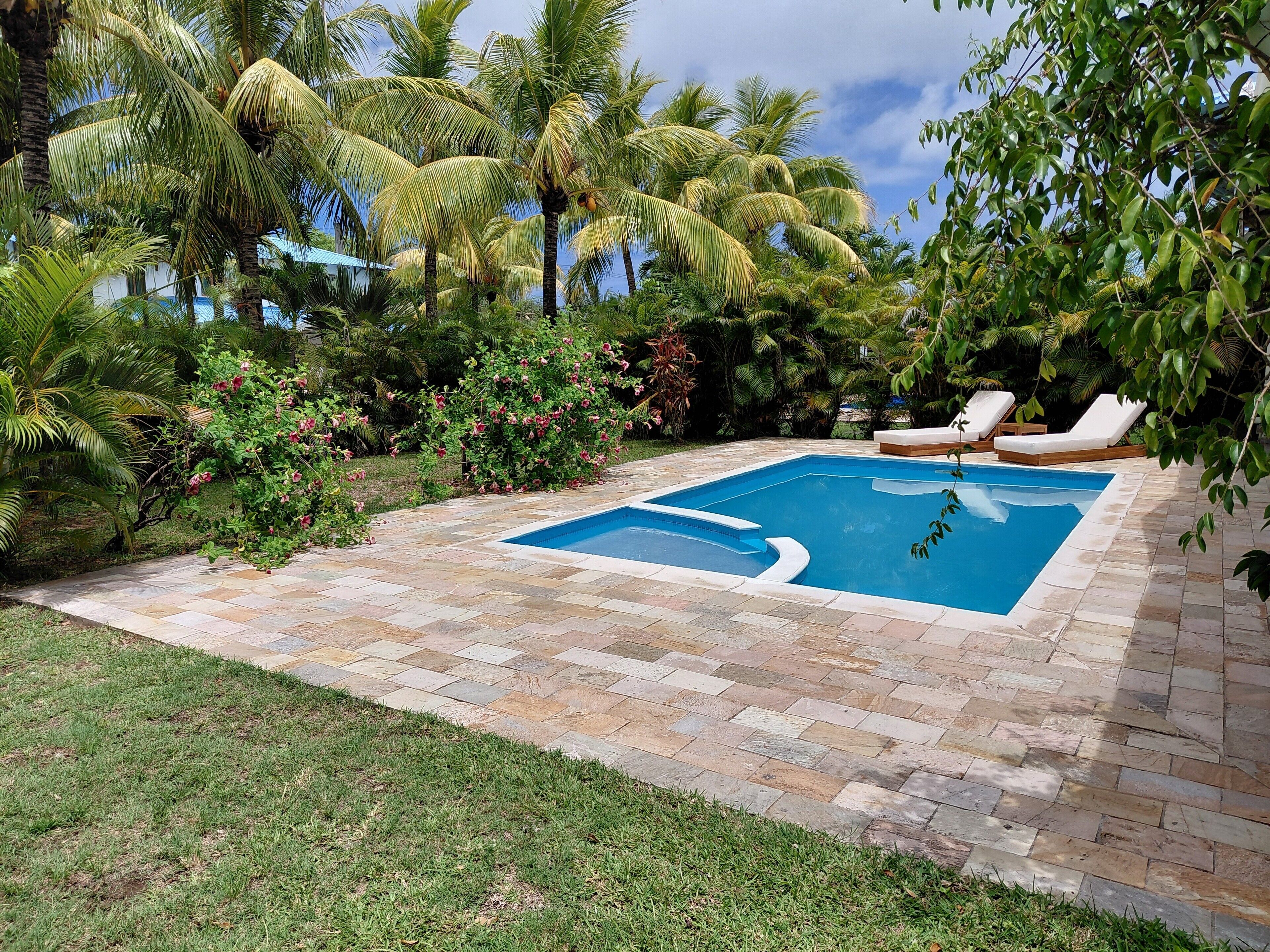 Una piscina al aire libre, sillones reclinables de piscina