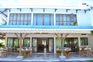 Frukost och lunch serveras, med utsikt mot trädgården 