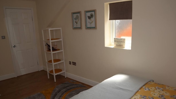 Ein Schlafzimmer mit Bett, Fenster mit Blick, einer weißen Tür und einem weißen Schrank.