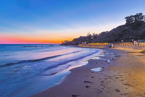 A beach with a sunset, calm waters, and a coastal town in the background. - Marina Guest House by Biddizzi Rari - near the beach and veranda with sea view (Sciacca)