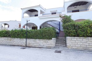 A white building with multiple arches and a staircase leading to a balcony. - Marina Guest House by Biddizzi Rari - near the beach and veranda with sea view (Sciacca)