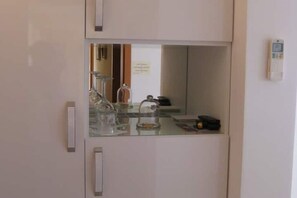 Eine Küche mit einer Glasabdeckungsplatte, einer Kaffeemaschine und einem Wasserkocher.
