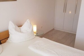 Ein Hotelzimmer mit einem Bett, einem Nachttisch mit Lampe und einem Kleiderschrank.