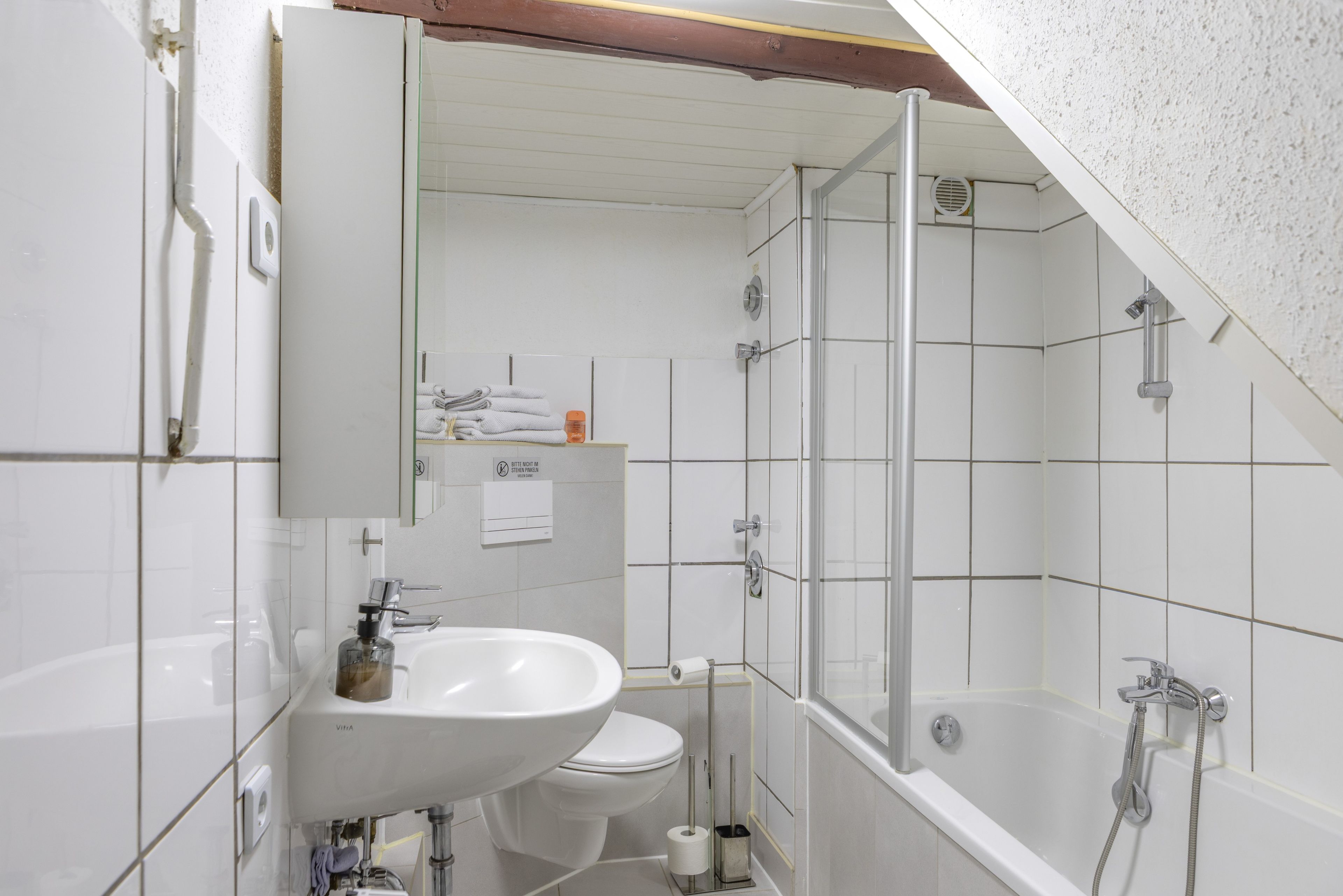 Ein Badezimmer mit Dusche, Toilette und Waschbecken.