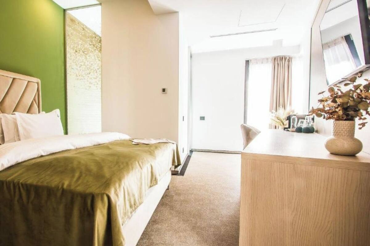 Una habitación de hotel con una cama, un escritorio y un espejo.