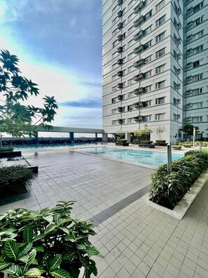 A modern building with multiple balconies and a swimming pool area. - Avida Towers Davao City Poblacion studio unit by darpm (Davao City)