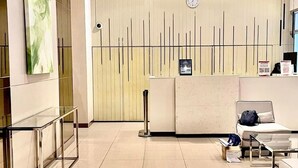 A modern hotel lobby with a reception desk, seating area, and a clock on the wall. - Avida Towers Davao City Poblacion studio unit by darpm (Davao City)