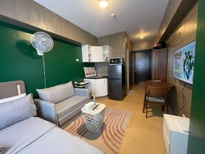 A compact living space with a kitchenette, a dining area, and a seating area. - Avida Towers Davao City Poblacion studio unit by darpm (Davao City)