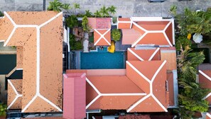 An aerial view of a hotel with a swimming pool, multiple rooms with geometric roof designs, and surrounding greenery. - Wonderland Amethyst Luxury Villa (Muang Pattaya)