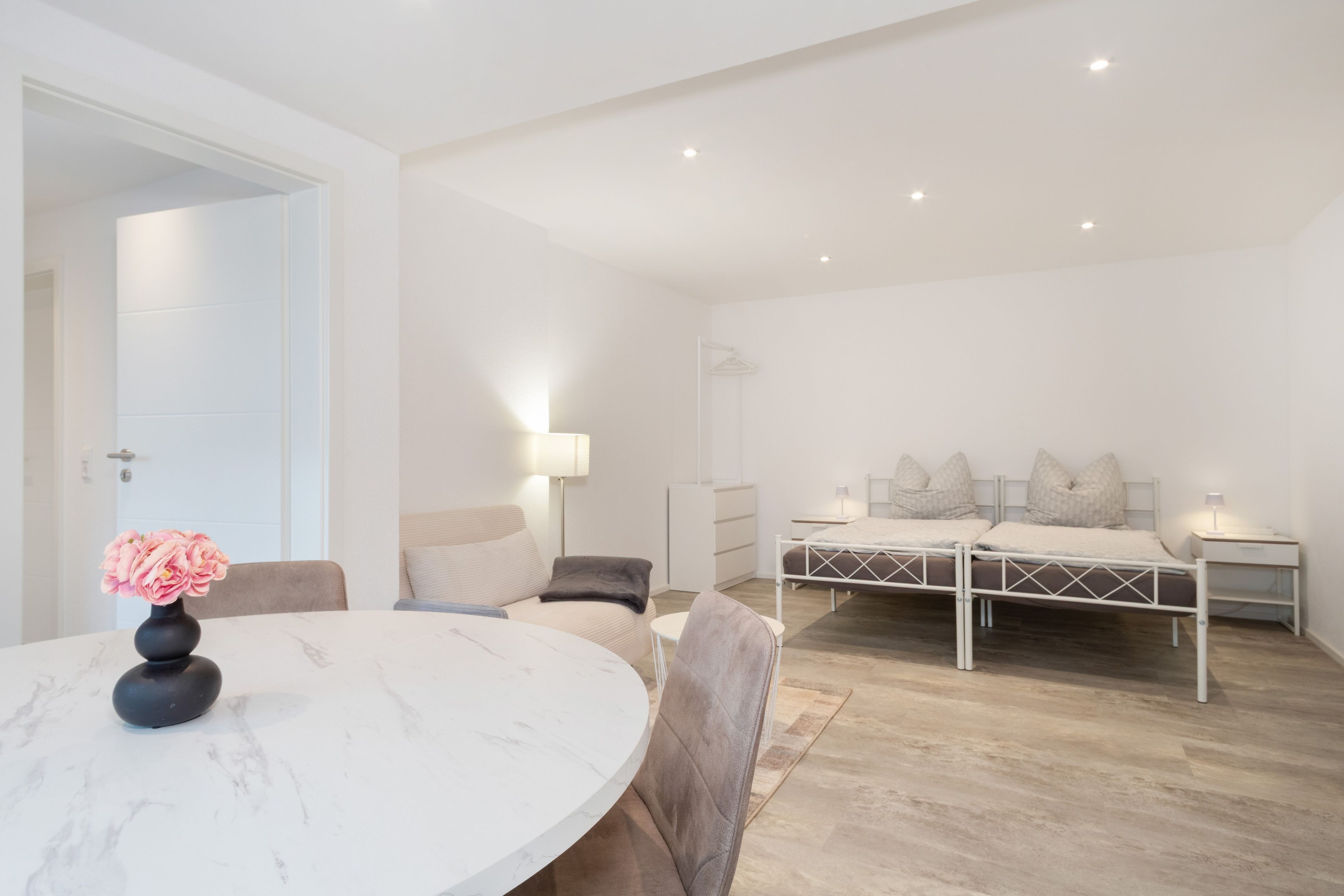 Ein modernes Schlafzimmer mit einem Bett, Nachttischen und einem kleinen Schreibtisch.
