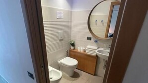 A modern bathroom with a toilet, bidet, and sink. - Parthenope b&b (Naples)