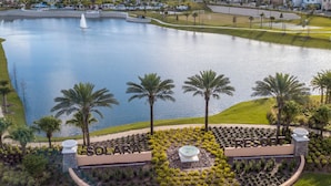 A resort with a large lake, palm trees, and a fountain. - 5Bd Villa Private Pool Spa at Solara Resort 1820 (Kissimmee)