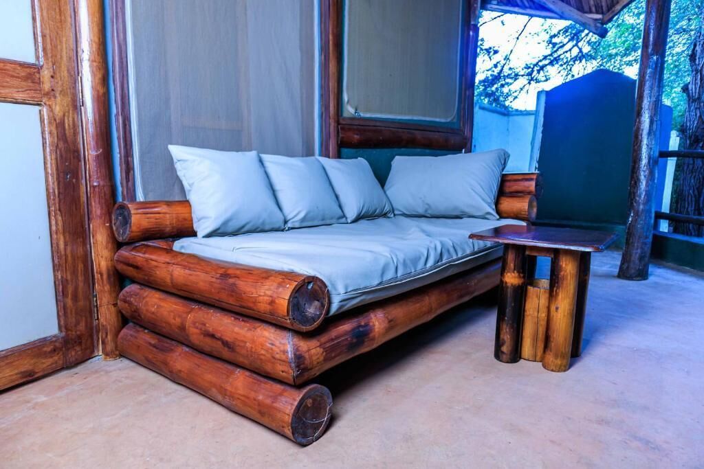 A log cabin-style room with a wooden bed and a small table.